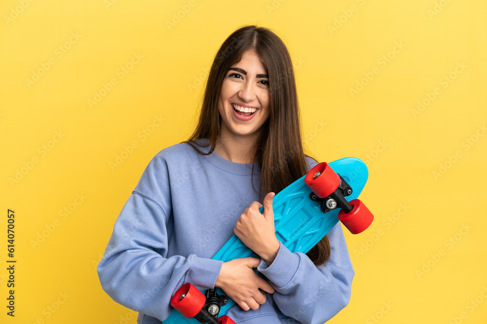 Young caucasian woman isolated on yellow background with a skate with happy expression Young caucasian woman isolated on yellow background with a skate with happy expression