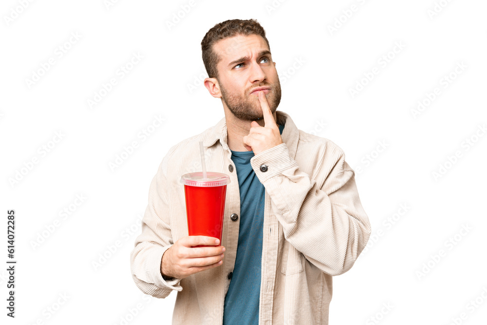 Young handsome blonde man holding soda over isolated chroma key background having doubts while looking up Young handsome blonde man holding soda over isolated chroma key background having doubts while looking up