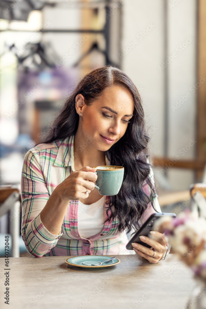 Portrait of beautiful woman using her smarphone in cafe, he reads received messages and follows social networks. Portrait of beautiful woman using her smarphone in cafe, he reads received messages and follows social networks.