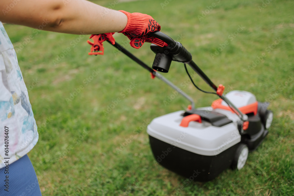 Lawn mover on green grass in modern garden. Machine for cutting lawns. Safety equipment with garden tools Lawn mover on green grass in modern garden. Machine for cutting lawns. Safety equipment with garden tools