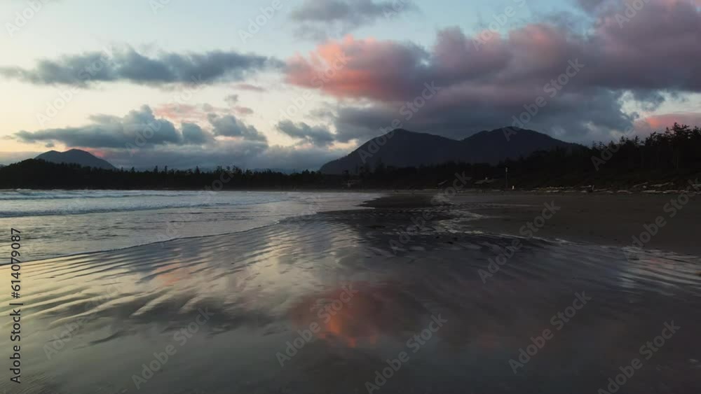 Wet beach sand reflecting twilight sky in Cox Bay, Tofino, Canada. Low aerial Wet beach sand reflecting twilight sky in Cox Bay, Tofino, Canada. Low aerial