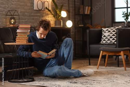 Young man reading book at h...