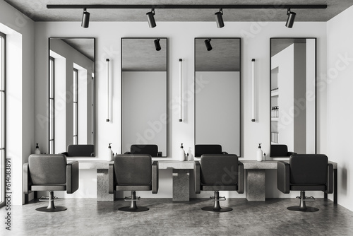 Light stylish barber shop with armchairs in row and mirror, accessories on table