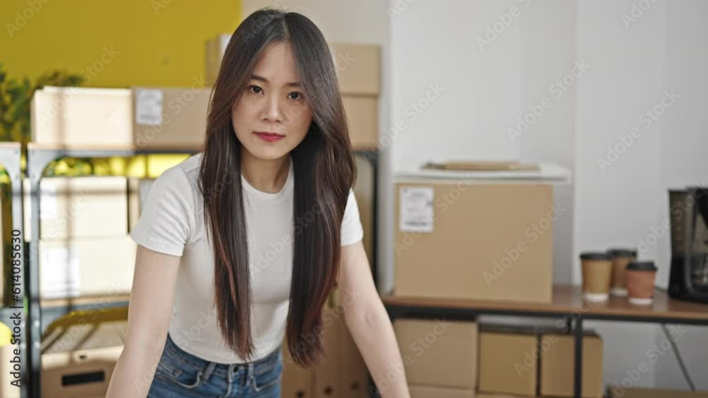 Young chinese woman ecommerce business worker using laptop standing at office Young chinese woman ecommerce business worker using laptop standing at office