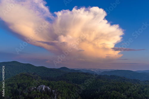 Large clouds at dusk above the forested mountains, Bijele stijene reserve in Croatia