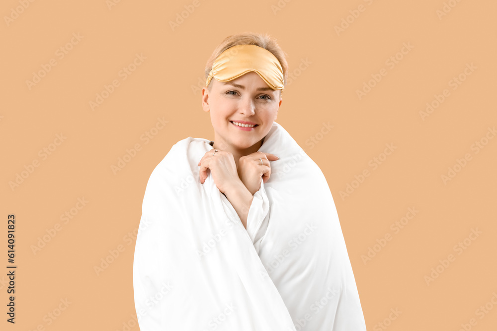 Young woman with sleeping mask and blanket on beige background Young woman with sleeping mask and blanket on beige background