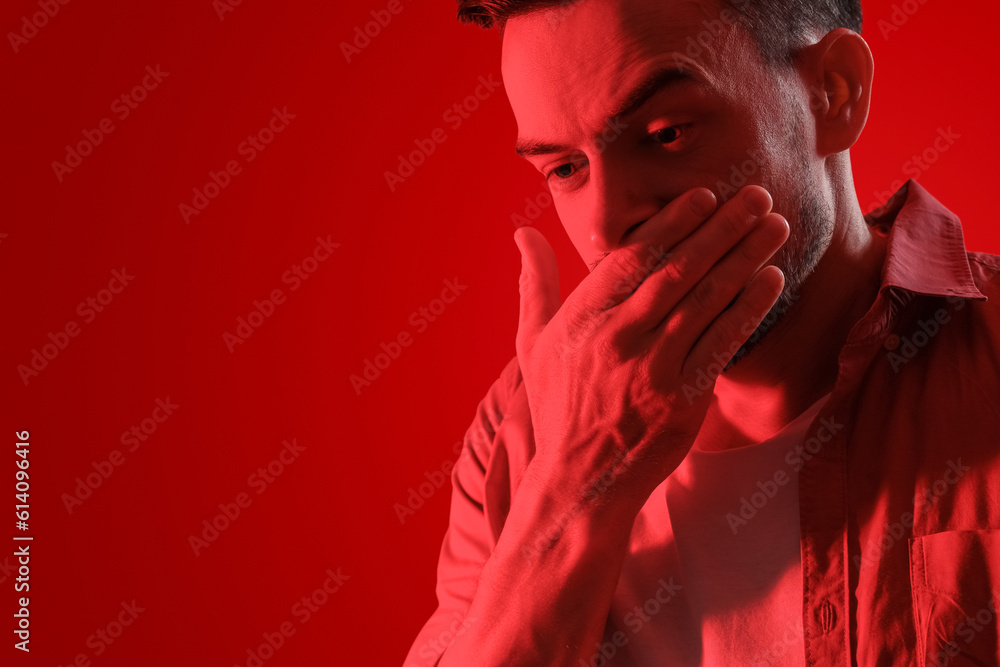 Young man having panic attack on red background, closeup Young man having panic attack on red background, closeup