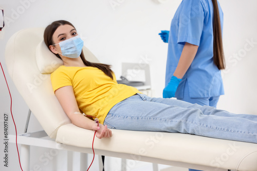 Young woman donating blood ...