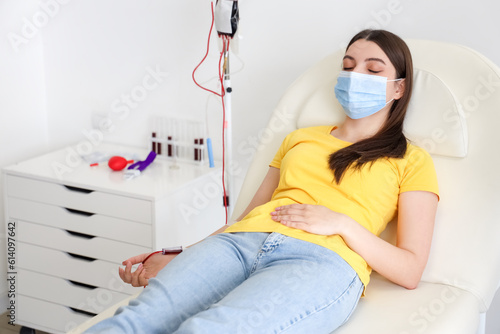 Young woman donating blood ...