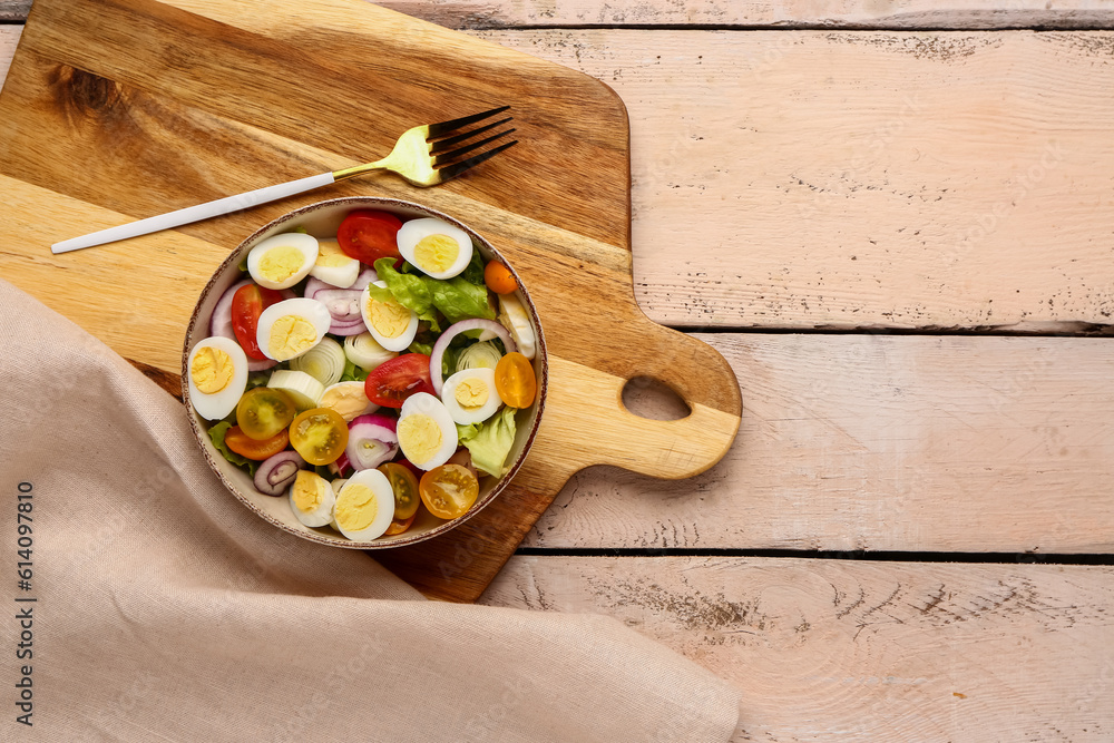 Tasty salad with quail eggs, tomatoes, onion and lettuce on light wooden background Tasty salad with quail eggs, tomatoes, onion and lettuce on light wooden background