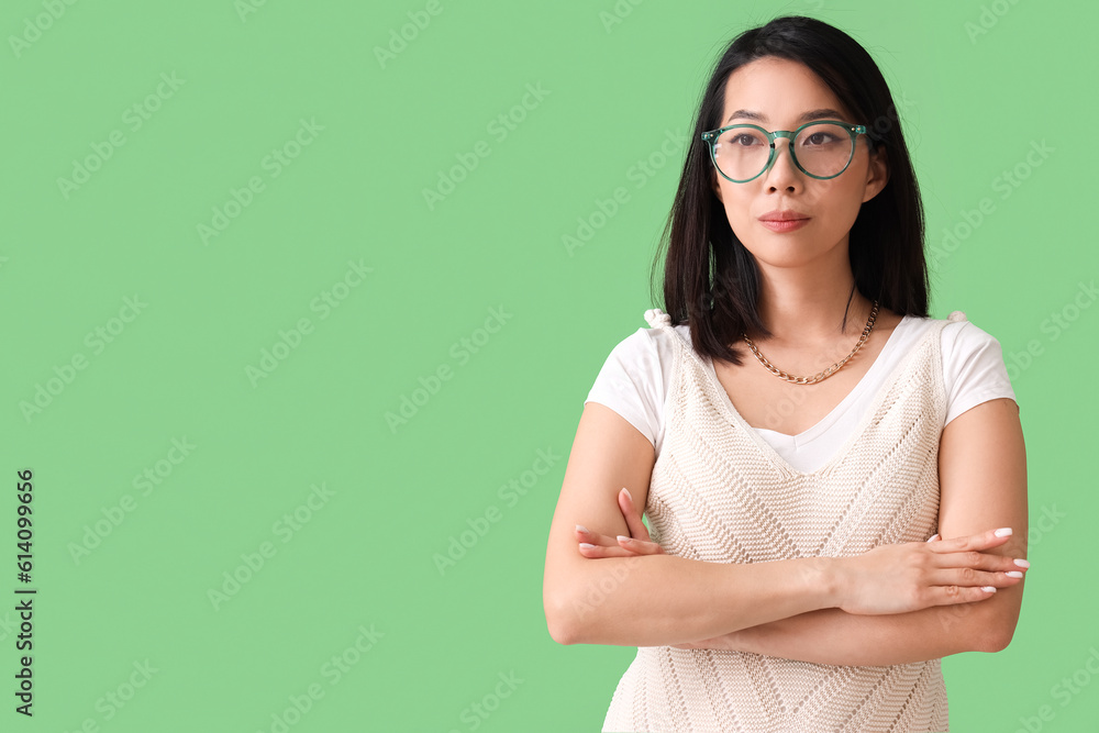 Beautiful Asian woman in stylish eyeglasses on green background Beautiful Asian woman in stylish eyeglasses on green background