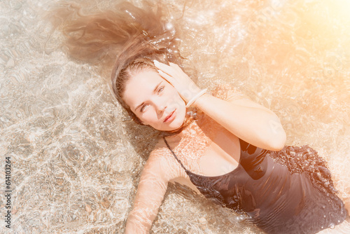 Woman summer travel sea. Happy tourist enjoy taking picture outdoors for memories. Woman traveler posing on the beach at sea surrounded by volcanic mountains, sharing travel adventure journey