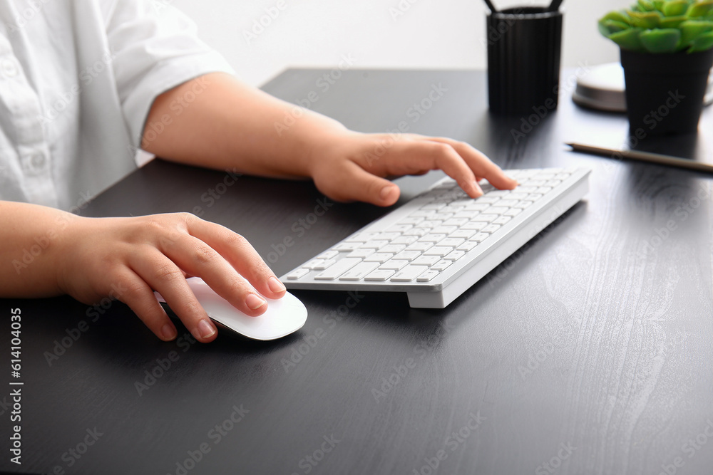 Female programmer using computer keyboard and mouse on table in office Female programmer using computer keyboard and mouse on table in office