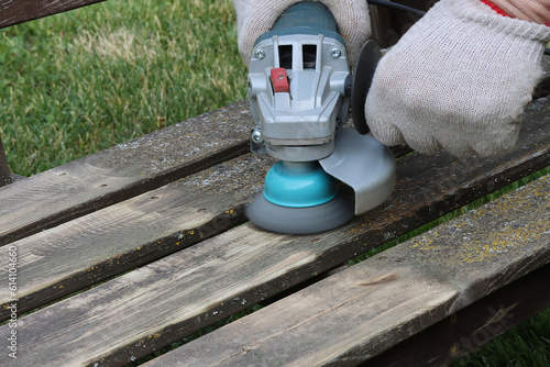 Φωτογραφία Removing lichens from a wooden surface of a garden bench with a metal brush and