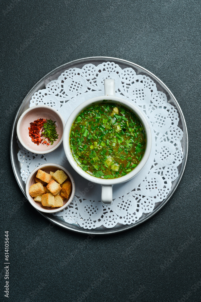 Chicken broth with parsley in a white bowl. Free space for text. Close up. Chicken broth with parsley in a white bowl. Free space for text. Close up.