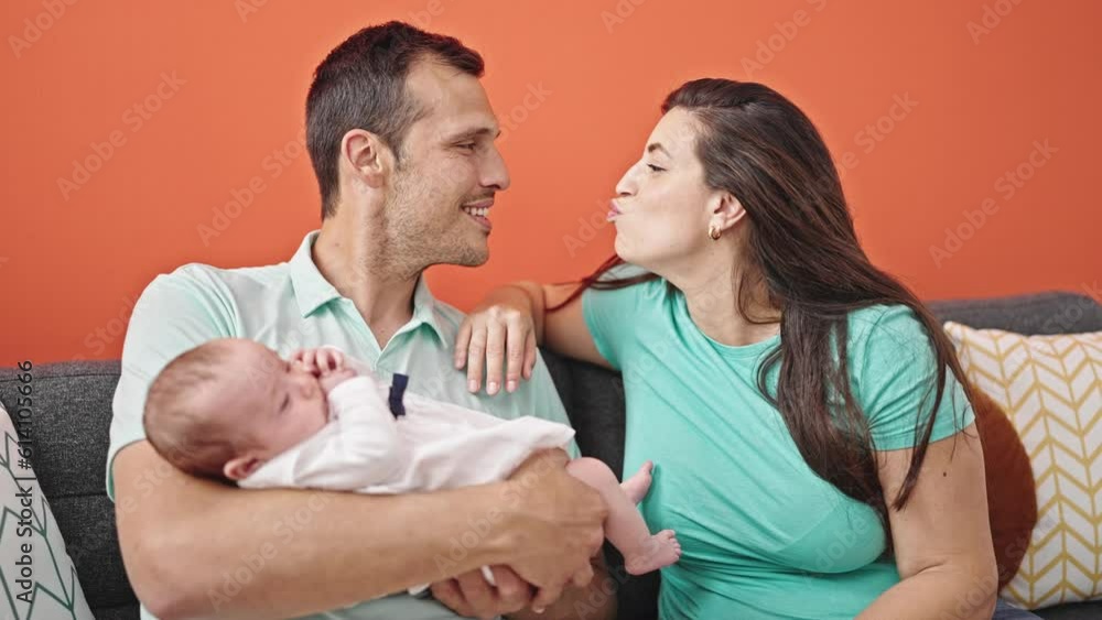 Family of three kissing sitting on the sofa at home Family of three kissing sitting on the sofa at home
