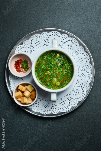 Chicken broth with parsley in a white bowl. Free space for text. Close up.