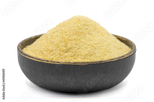 Dry organic semolina flour isolated on white background. Uncooked organic semolina in bowl. Close up photo