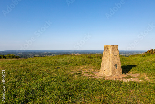 A concrete trig point on Ditchling Beacon with a blue sky overhead