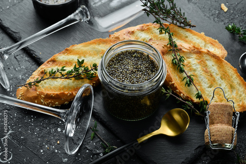 Beluga black caviar and toast bread. Preparation of luxury snacks. On a concrete background.