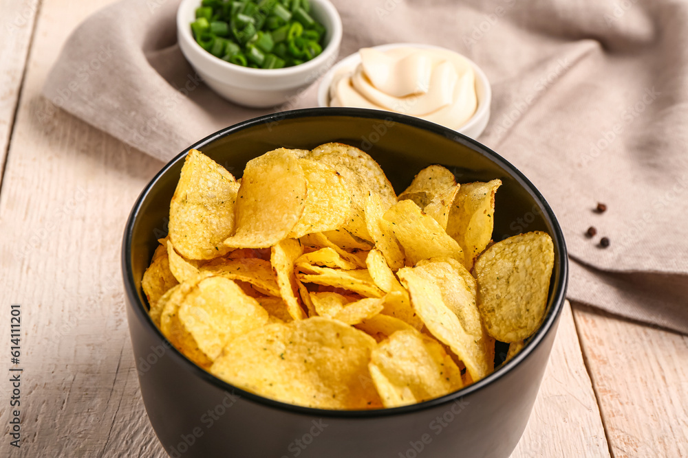 Bowls of tasty sour cream with sliced green onion and potato chips on white wooden background Bowls of tasty sour cream with sliced green onion and potato chips on white wooden background