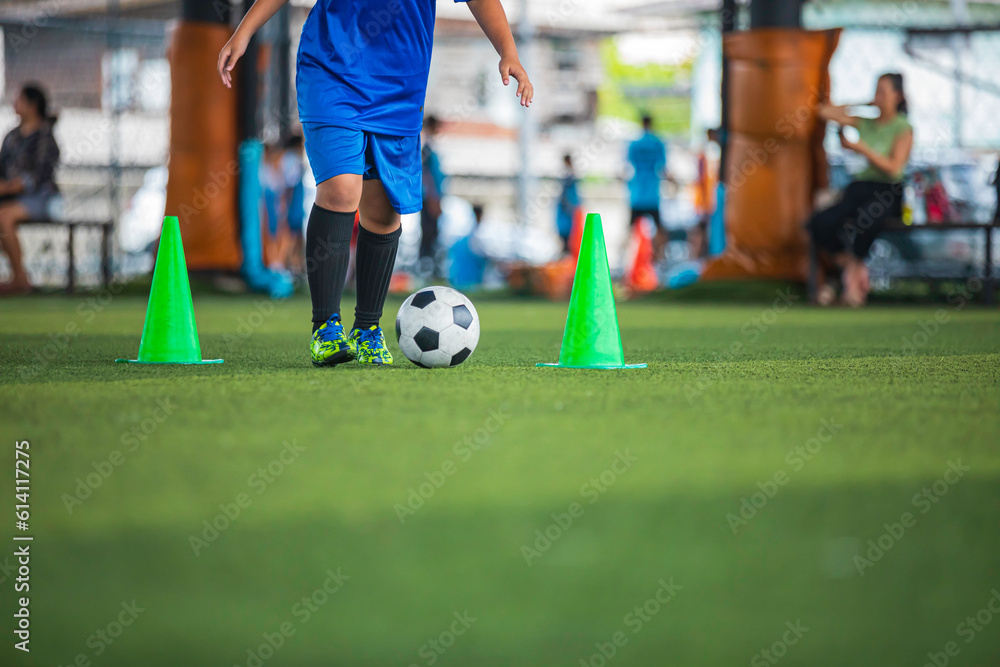 Obraz premium Soccer ball tactics children control the ball on a grass field with a cone for training Thailand in background training