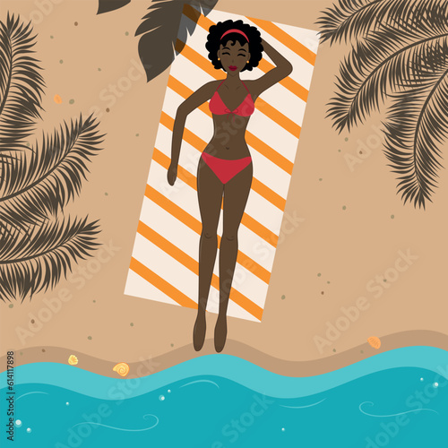 Beautiful girl in a swimsuit sunbathing on the beach near the sea