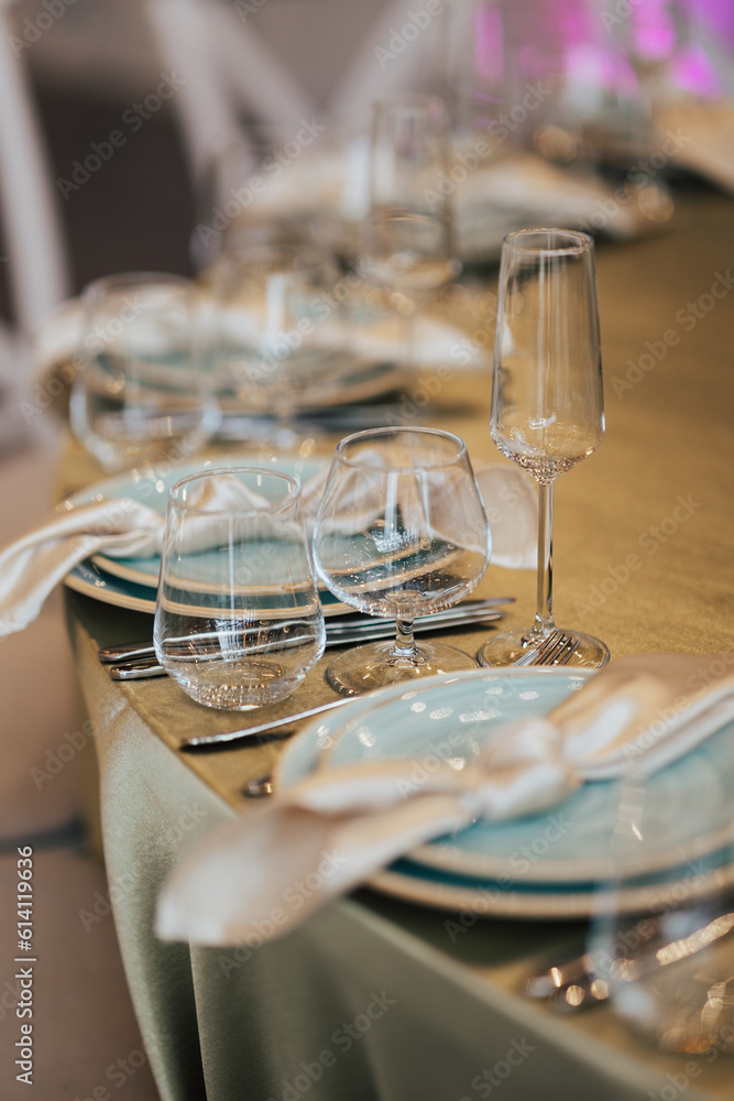 Table setting with plates, glasses and napkins for holidays dinner.