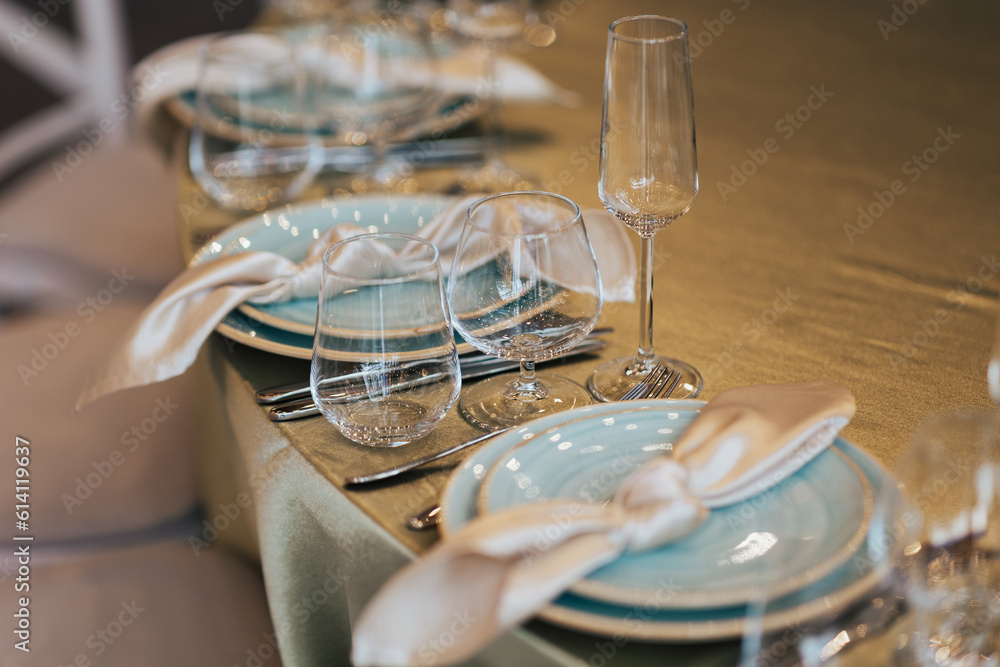 Table setting with plates, glasses and napkins for holidays dinner.