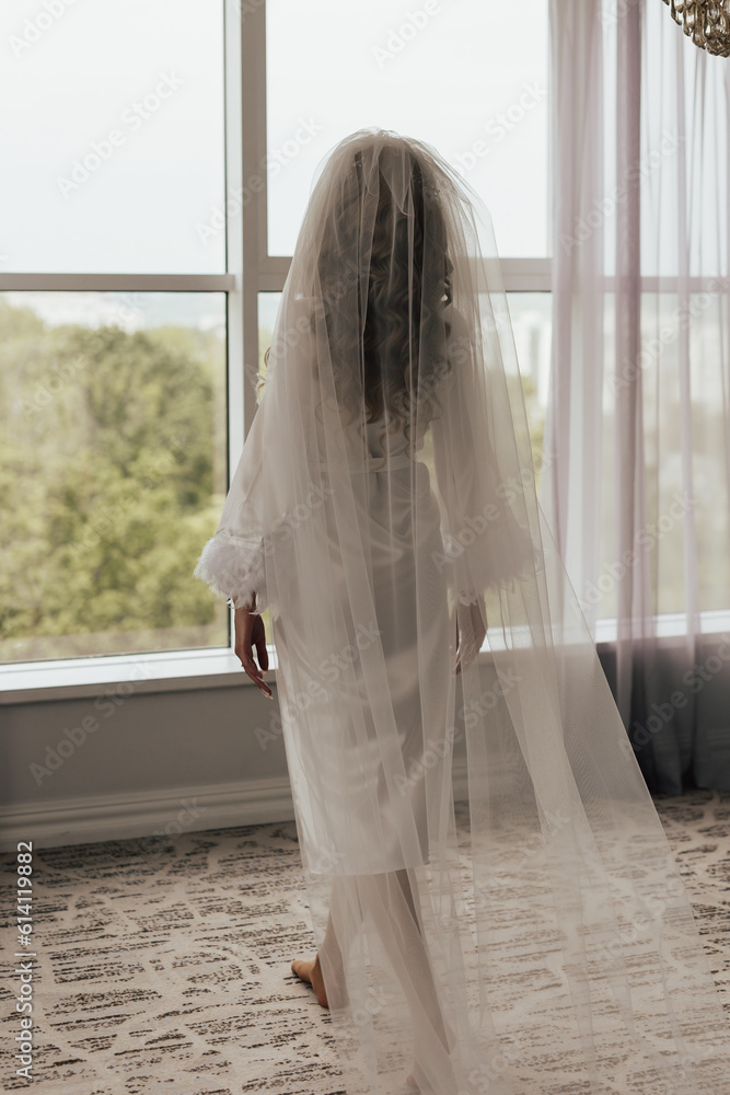 Young bride going to the window in the bridal morning
