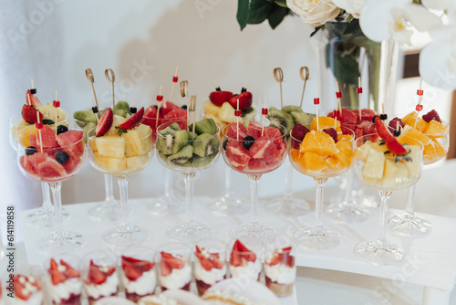 Obraz na płótnie Different fruits and berries in glasses. Catering on wedding. Sweet table with fruit, wedding catering. Fruit bar on party. w salonie