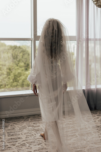 Obraz na płótnie Young bride going to the window in the bridal morning w salonie