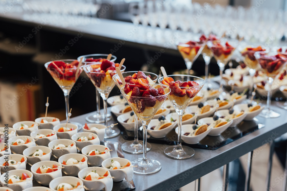 Strawberries and ananas in glasses. Catering on wedding. Sweet table with fruit and desserts, wedding catering. Fruit bar on party.