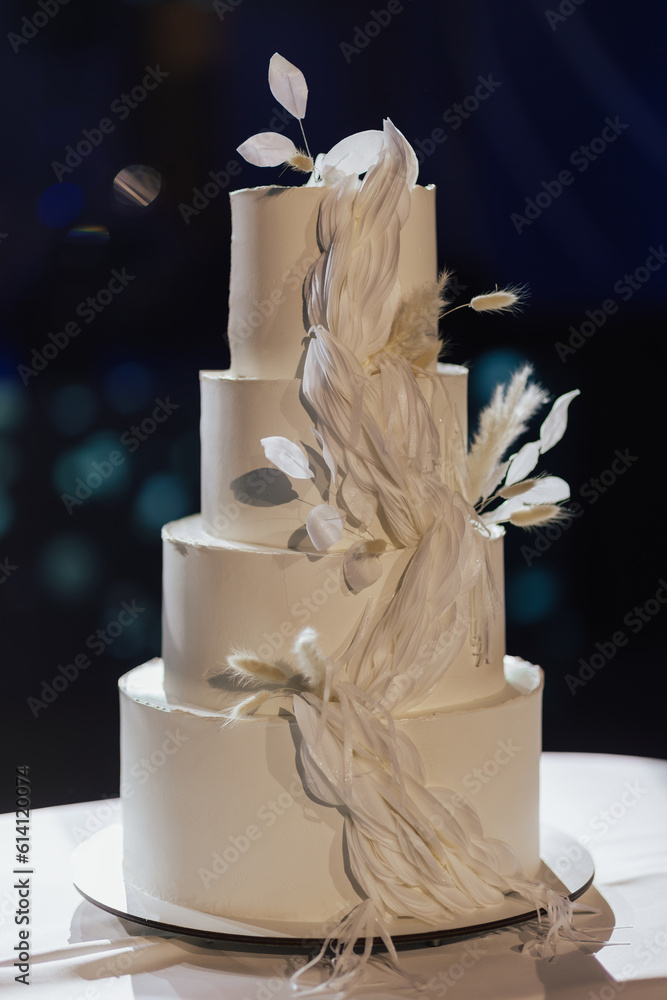 White wedding cake decorated with white flowers.
