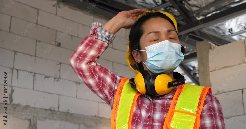 Female worker with construction site, hard worker, worker taking off helmet at construction site Female worker with construction site, hard worker, worker taking off helmet at construction site