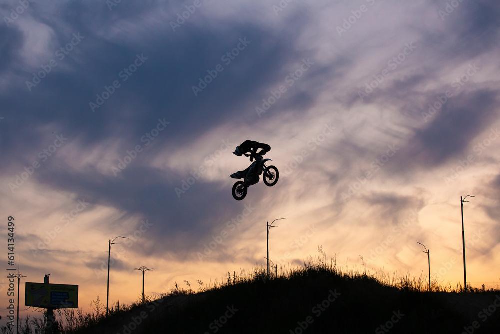 FMX rider performs dangerous stunts at sunset. Motocross. FMX rider performs dangerous stunts at sunset. Motocross.