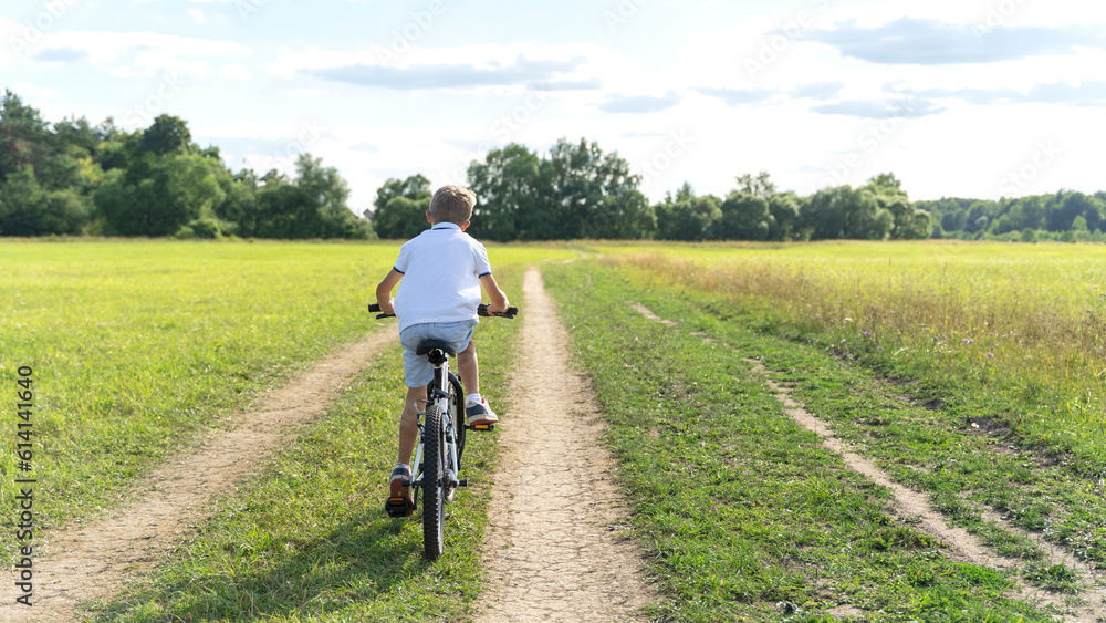 a boy rides a bicycle in nature