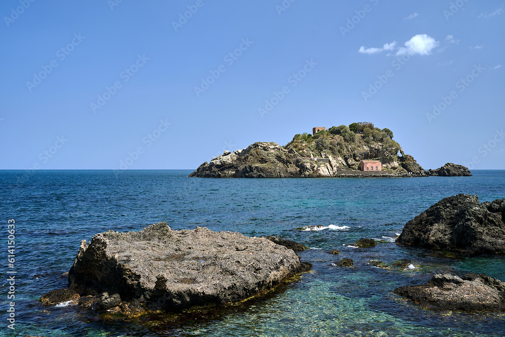 Rocky islet with historic buildings on the Cyclops coast in Italy