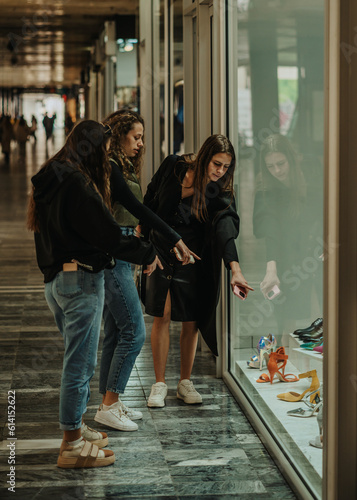Girls looking at the shop window in the shopping mall