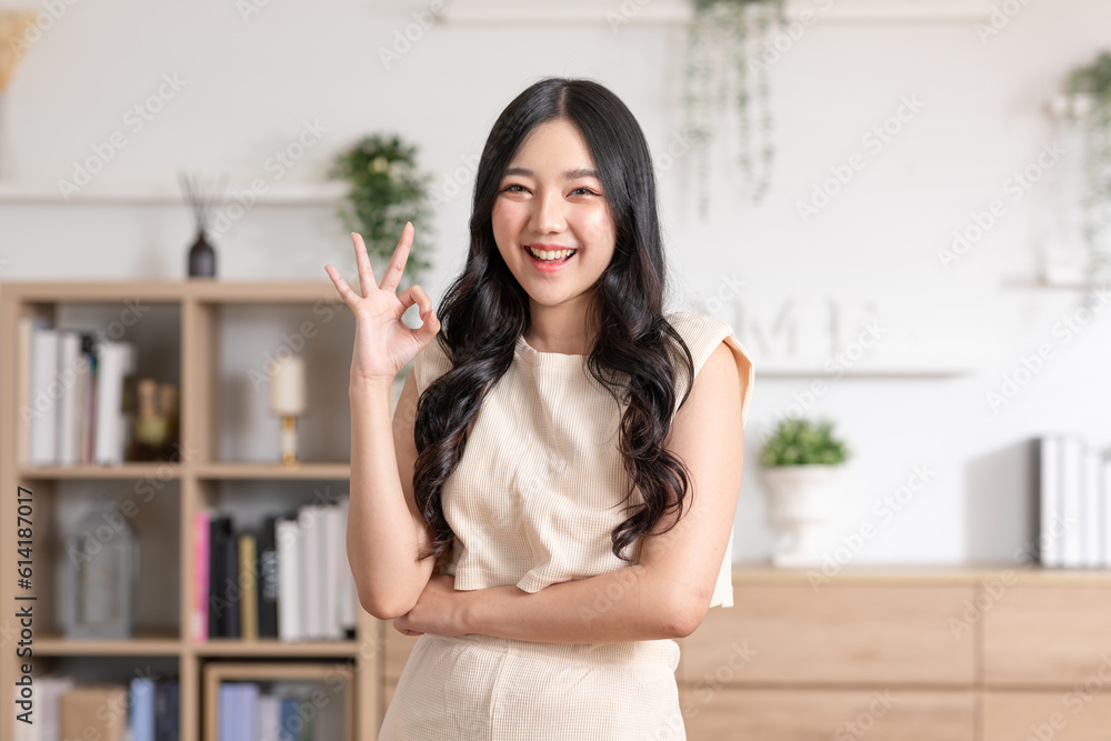 Beautiful young Asian woman showing thumbs up OK gesture smile with positive emotional at home. Attractive female making okay hand sign or say yes happiness and cheerful. Women lifestyle concept Beautiful young Asian woman showing thumbs up OK gesture smile with positive emotional at home. Attractive female making okay hand sign or say yes happiness and cheerful. Women lifestyle concept