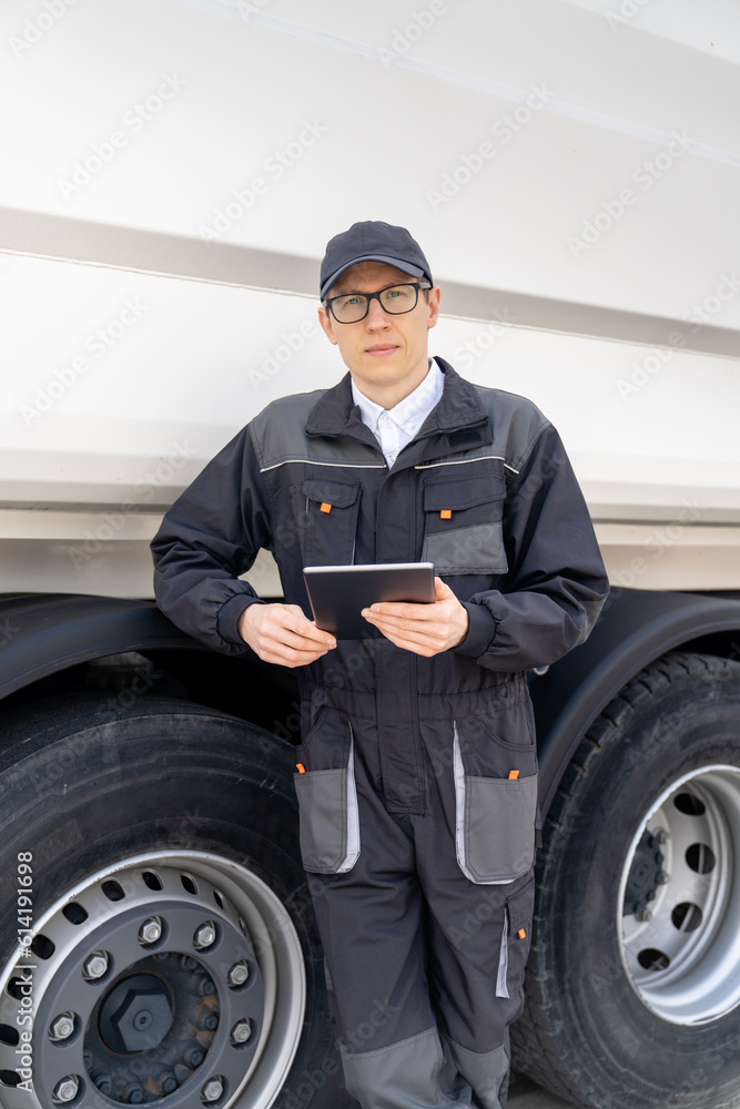 Manager with a digital tablet next to garbage truck.. Manager with a digital tablet next to garbage truck..