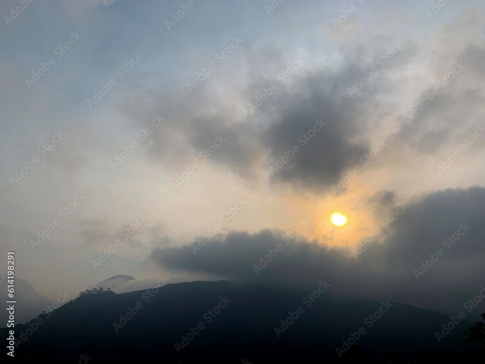 Sun rising among the clouds in the mountains.