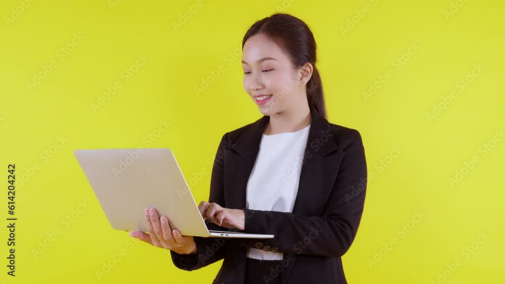 Portrait young asian business woman standing work on laptop computer to internet online on yellow background, businesswoman in suit confident and using notebook, marketing and communication. Portrait young asian business woman standing work on laptop computer to internet online on yellow background, businesswoman in suit confident and using notebook, marketing and communication.