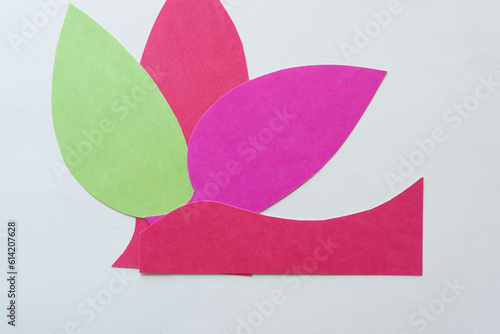 three paper shapes (green, red, and pink) on blank paper