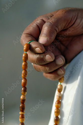 hand holding a misbaha rosary for religious reading, dhikr and remembrance 