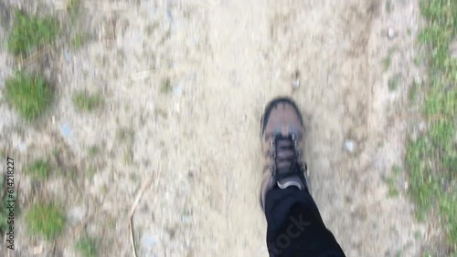 Walking thru the nature video of a man or woman with hiking shoes recorded from the top