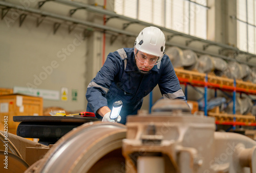 Professional technician or engineer worker hold light stick to check and fix the problem of part of electric train in factory or maintainence center.