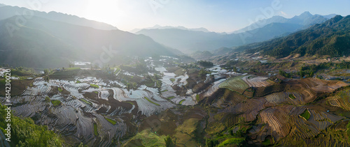 The pouring water season makes the terraced fields of Y Ty commune, Lao Cai province, Vietnam appear with brown soil blending with the beautiful sky. © CravenA
