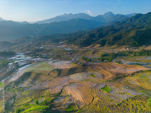 The pouring water season makes the terraced fields of Y Ty commune, Lao Cai province, Vietnam appear with brown soil blending with the beautiful sky. © CravenA