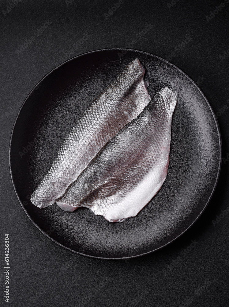 Raw sea bass fish fillet with salt, spices and herbs on a ceramic plate - obrazy, fototapety, plakaty 